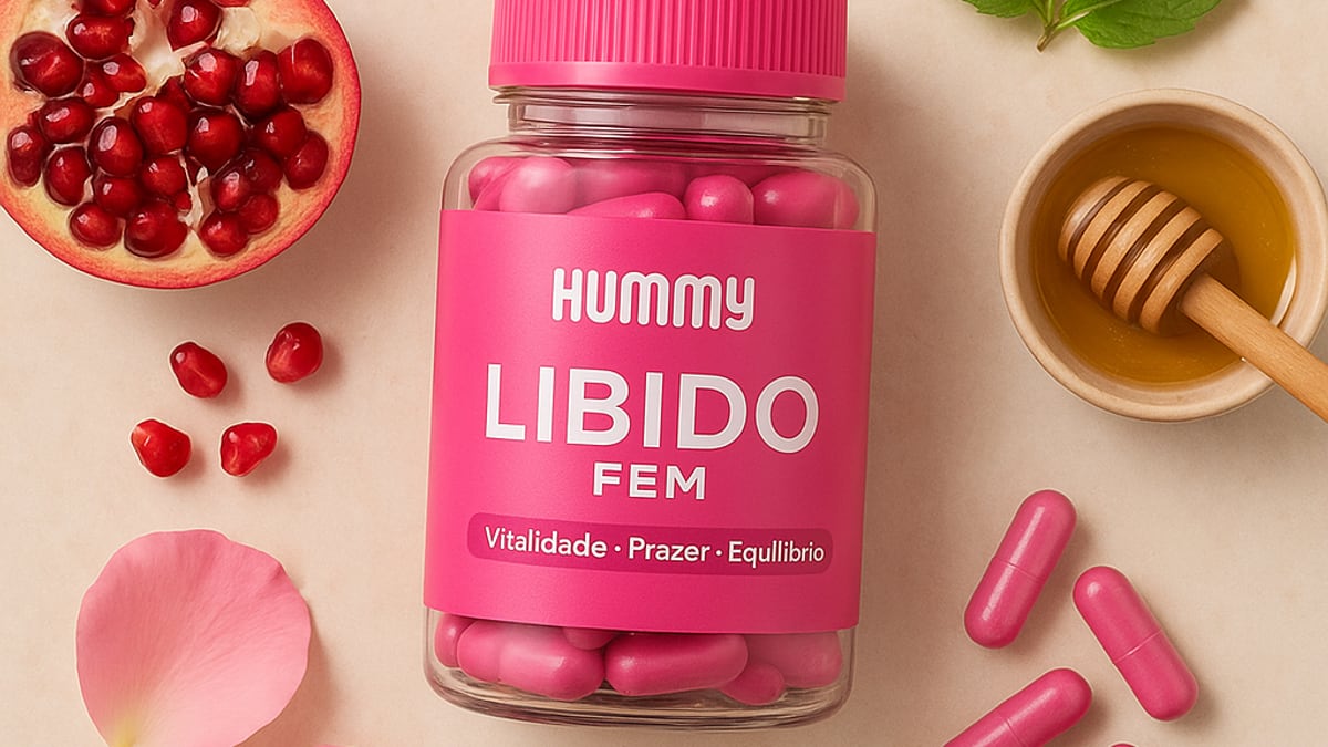 Frasco de Hummy Libido Fem sobre uma penteadeira, ao lado de uma vela acesa e um livro