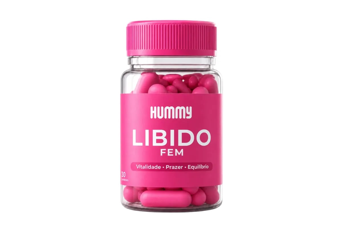 Mulher segurando o frasco de Hummy Libido Fem na frente do espelho do banheiro, luz suave