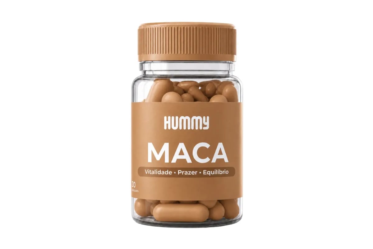 Mão segurando o frasco de Hummy Maca com uma cápsula na palma, luz natural de janela