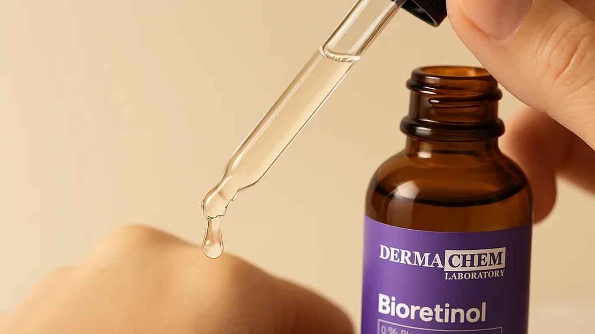 Frasco do Sérum Bioretinol Hummy sobre bancada de mármore ao lado de um espelho redondo